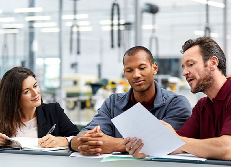 Employees discussing business plans together at the factory.