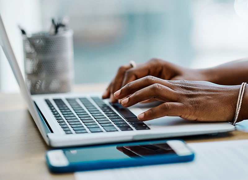 hands of an african american woman using a laptop.