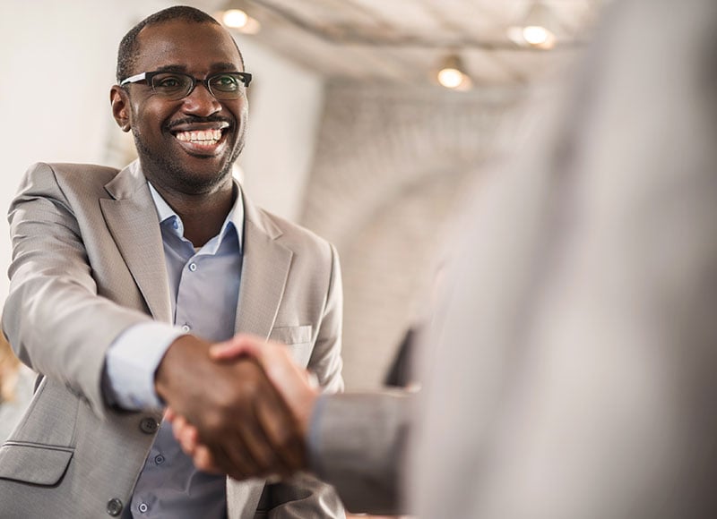 Man gives a warm handshake to his business partner,