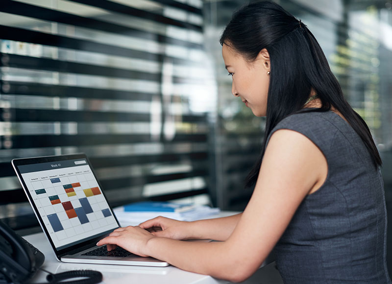 Woman checks the calendar on her computer at work.