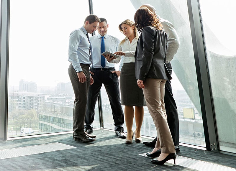 A group of employees stand together in their new office space.