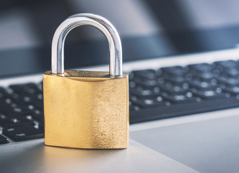 gold padlock sitting next to a black keyboard